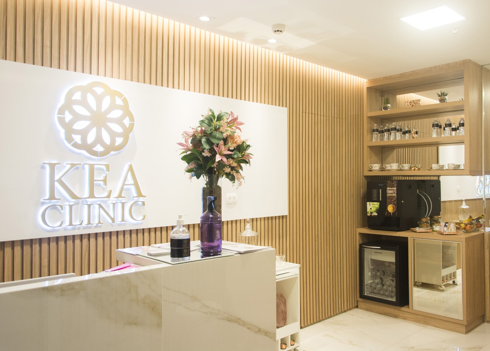 Kea Clinic — recepção com logo iluminado e painel de madeira, Jardins, São Paulo